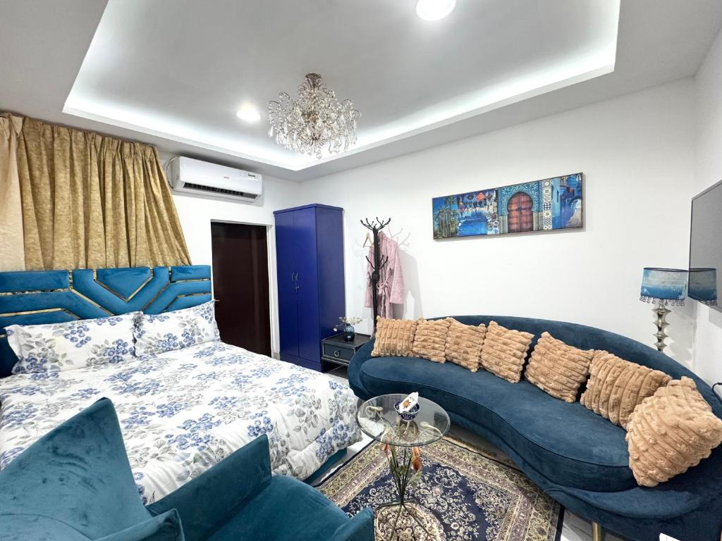 a bedroom with a blue bed and a couch at Velmora Villas room 14 in Abu Dhabi