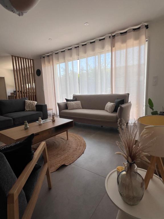 a living room with a couch and a table at NeseHome, Maison à proximité du Futuroscope in Montamisé