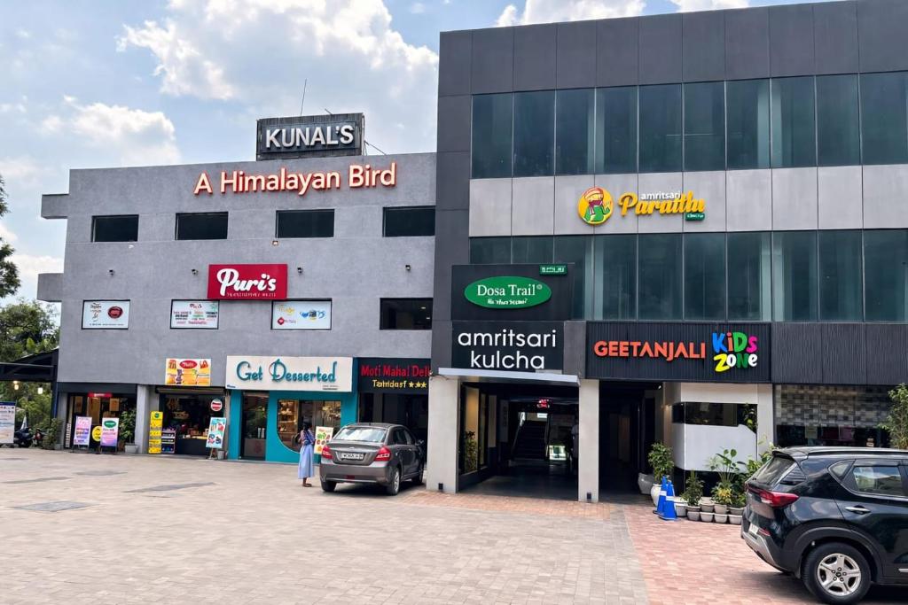 a building with cars parked in a parking lot at KUNAL'S- A Himalayan Bird in Mandi