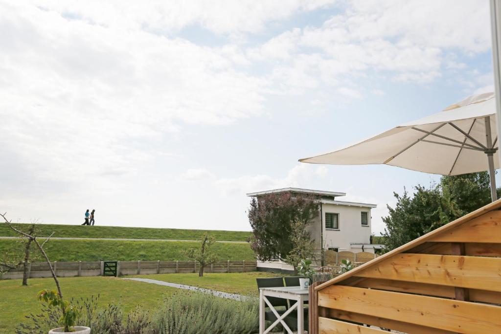 een patio met een parasol en een huis bij Het Vlielandhotel in Oost-Vlieland