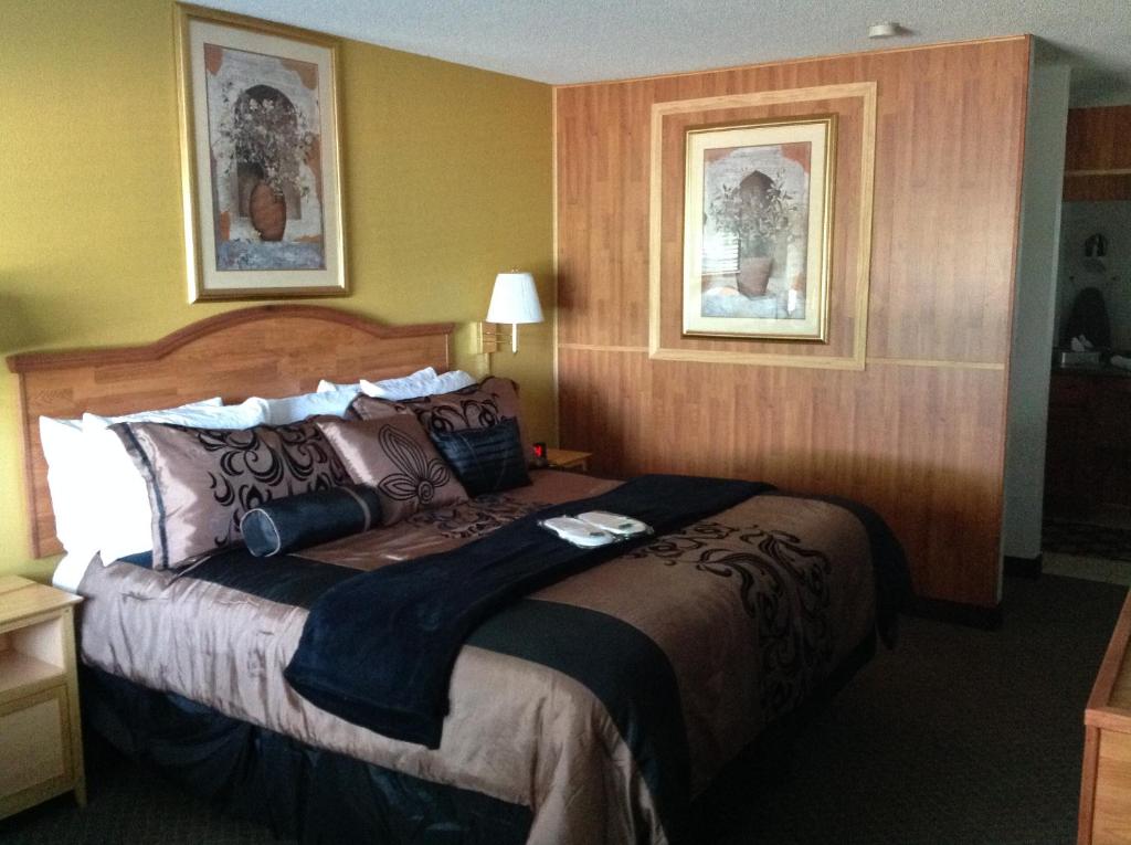 a bedroom with a large bed in a hotel room at Hallmarc Inn & Suites of West Memphis in West Memphis