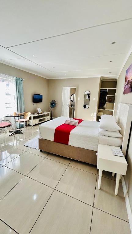 a bedroom with a large bed and a living room at Hidden Bliss Guesthouse in East London