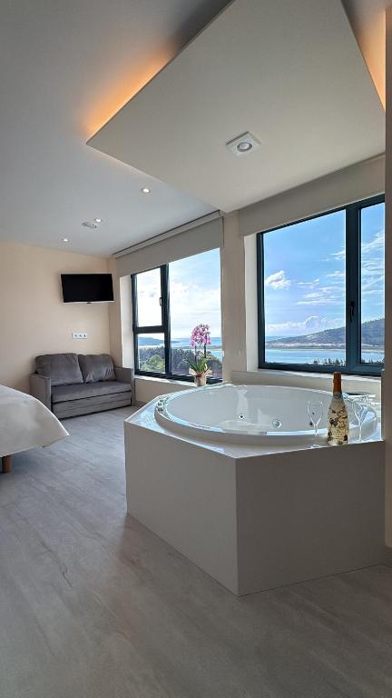 a large bathroom with a large tub with windows at O NAUTICO suites in Cabana de Bergantiños