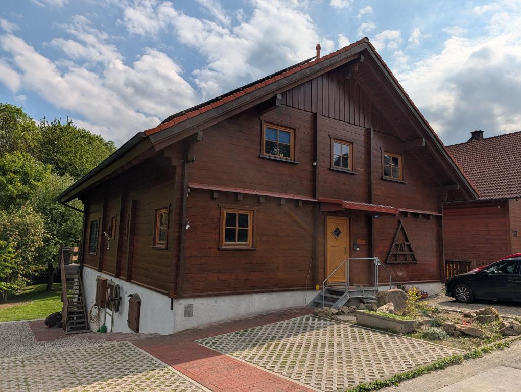 a house with a car parked in front of it at FeWo Aus'm Garten im Holzblockhaus nähe Aachen in Eschweiler