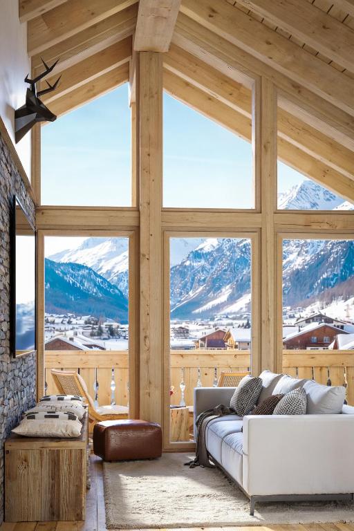 a living room with a couch and a large window at Ma Chérie in Livigno