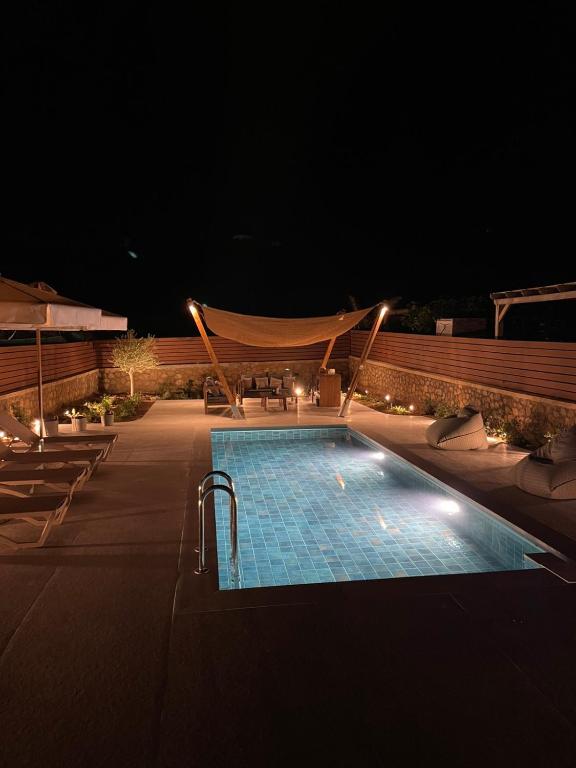 a swimming pool at night with lights on it at Villa Sunrise by the Sea in Kiotari