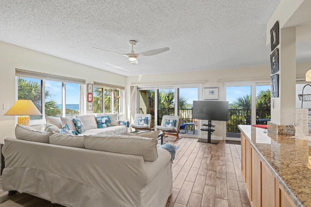 a living room with white couches and a television at Land's End 8-301 Beach Front in St. Pete Beach