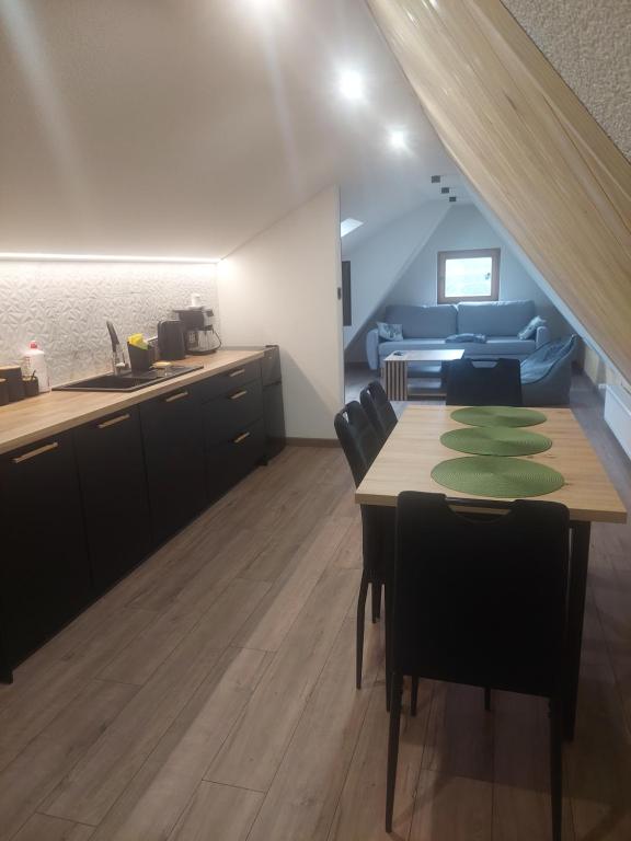 a kitchen and dining room with a table and a couch at Pod skosem in Witów
