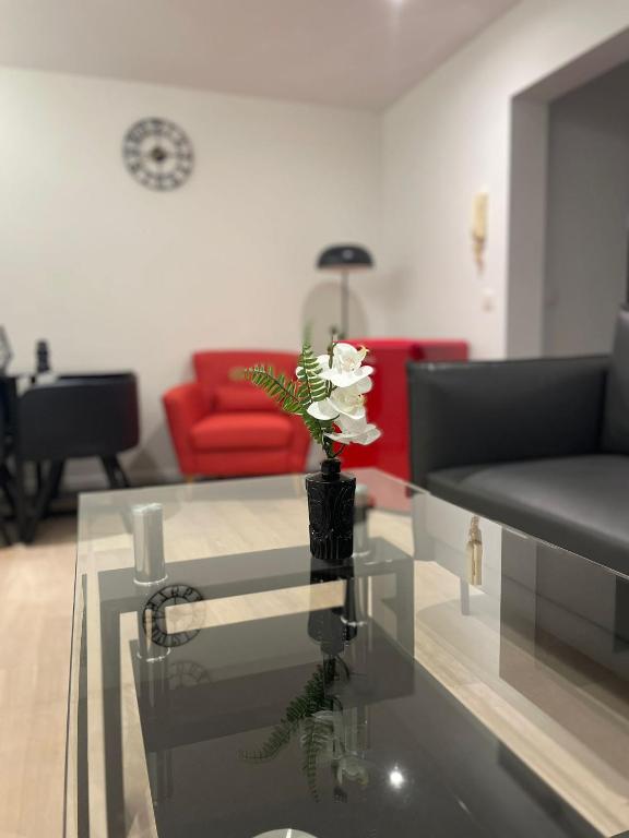 a living room with a vase with a flower on a glass table at Coquille in Nieuwpoort
