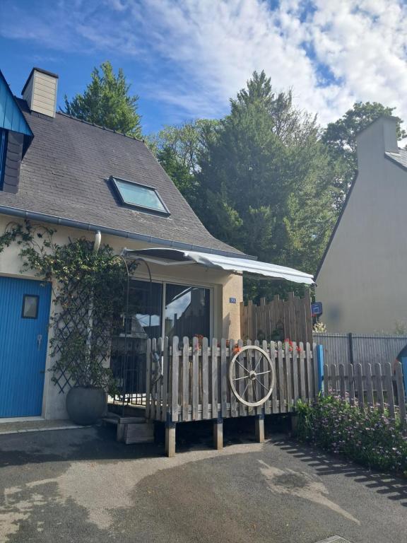 a fence in front of a house with a porch at Duplex du Bois d'Amour in Quimper
