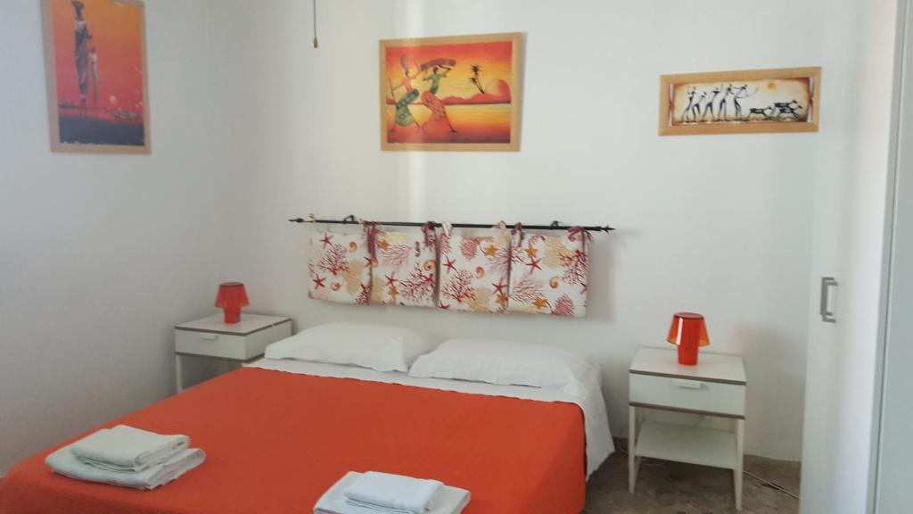 - une chambre avec un lit rouge et 2 tables de chevet dans l'établissement La casetta 5P, à Santa Flavia