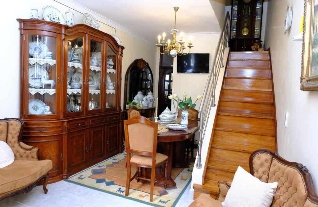 a dining room with a china cabinet and a table at Gods Barn House in Viana do Castelo