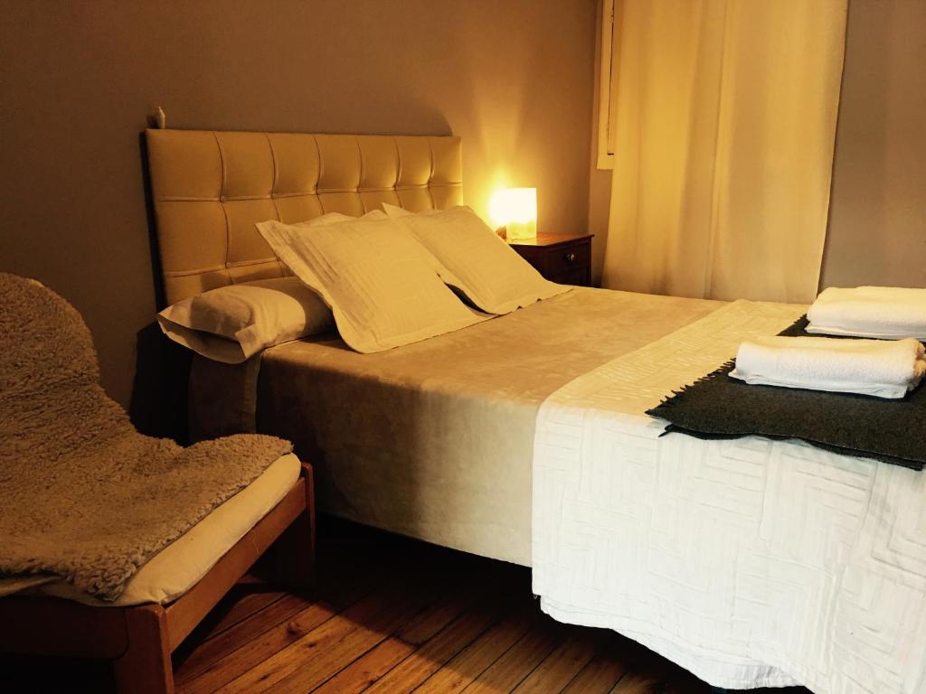 a bedroom with a large bed and a chair at Apartment Lugo Rooms in Lugo