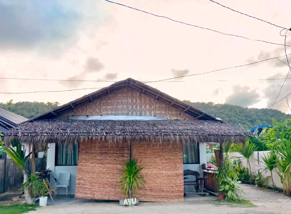 a small brick house with a thatched roof at Ayu Homestay - Room 3 in San Isidro