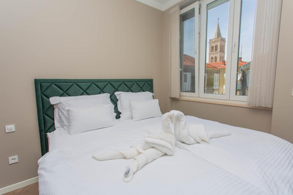 a bedroom with a bed with white towels on it at Luxury Rooms by Iva in Zadar