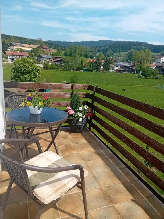 a patio with a table and chairs and a fence at Ferienwohnung in Arrach