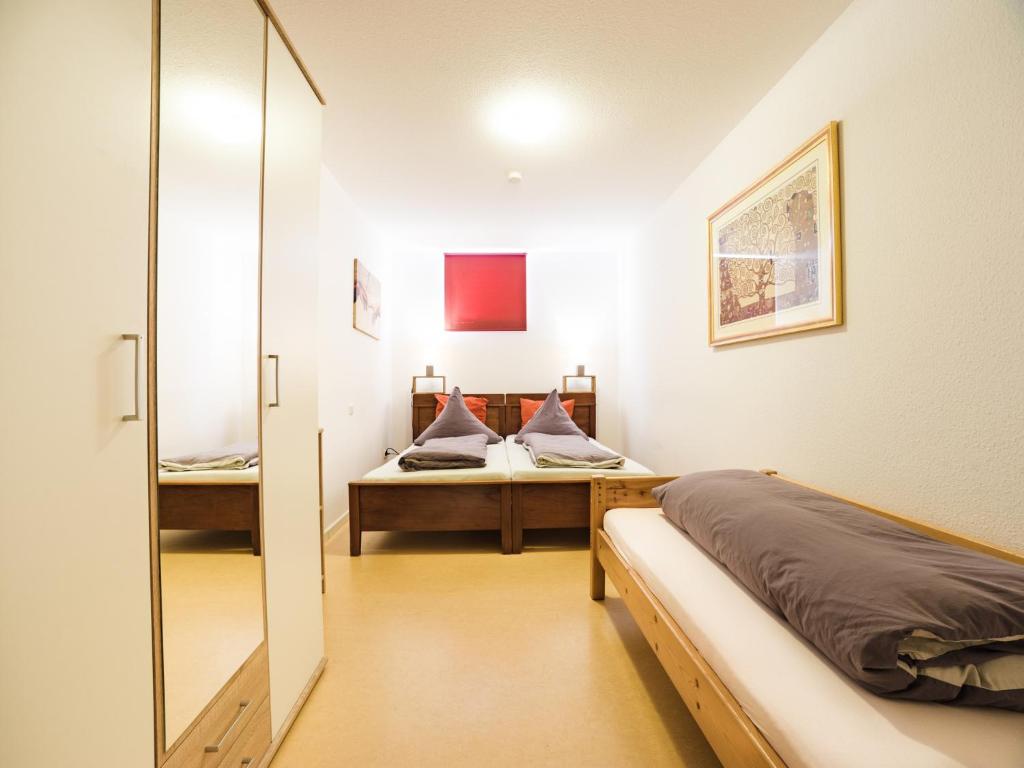 フルダにあるPension & Appartments Landhaus Bettina Fuldaのベッドルーム1室(ベッド2台、鏡付)