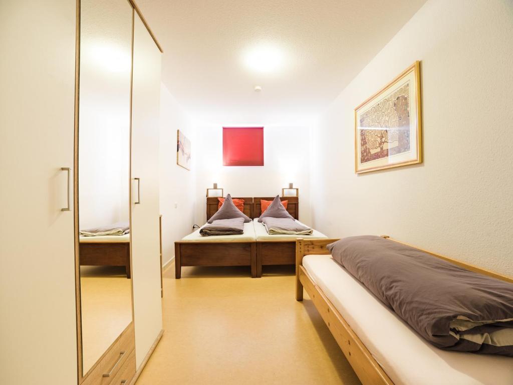 een slaapkamer met twee bedden en een spiegel bij Pension & Appartments Landhaus Bettina Fulda in Fulda