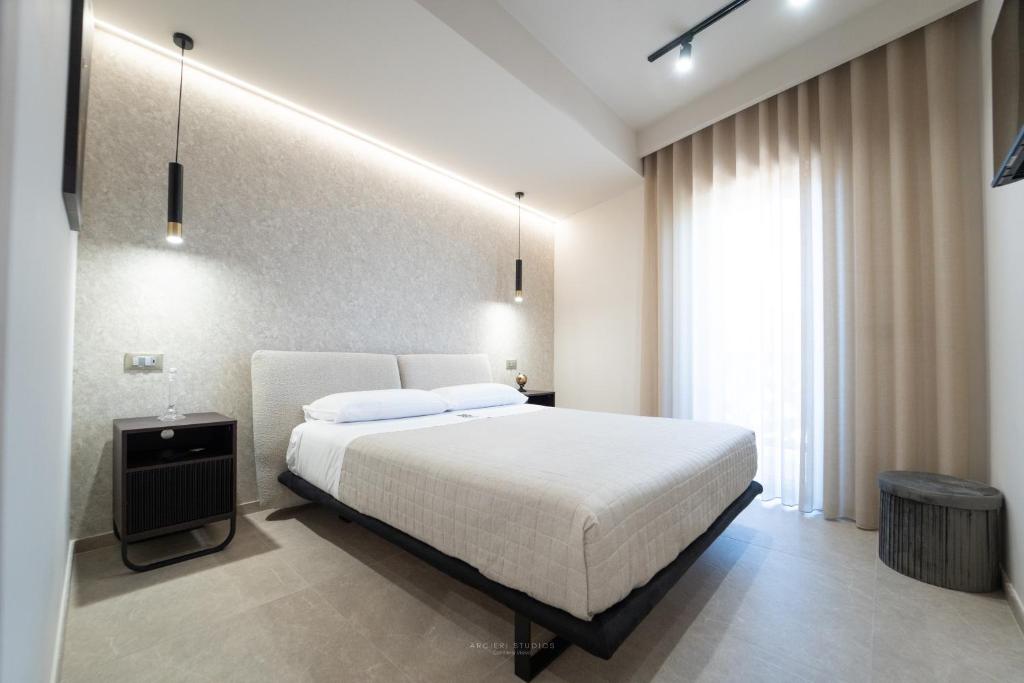 a bedroom with a white bed and a large window at HERMES Luxury Home in Agrigento