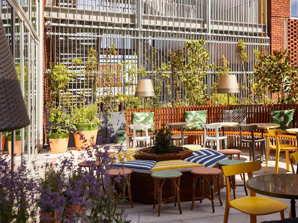 a patio with tables and chairs and potted plants at Mama Shelter Lille in Lille