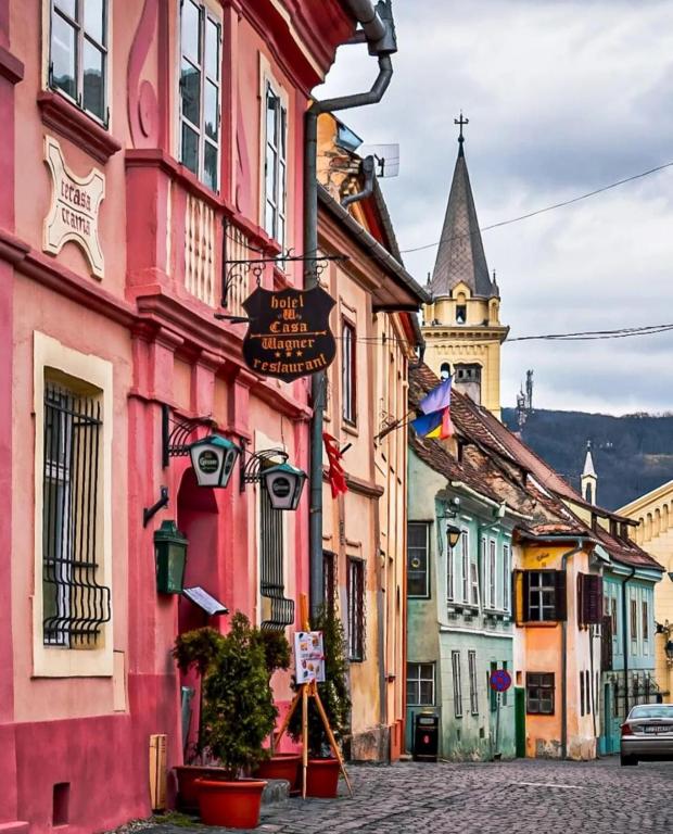 a group of buildings on a street with a church at Hotel Casa Wagner in Sighişoara