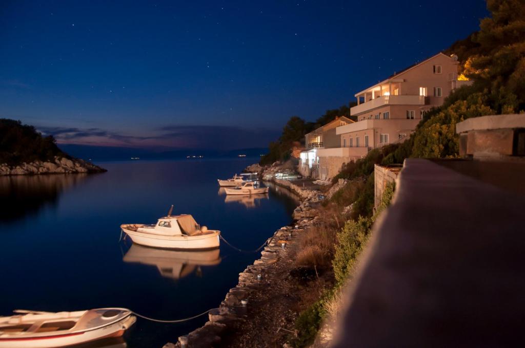 a group of boats docked in a harbor at night at Apartments Hropić in Lastovo