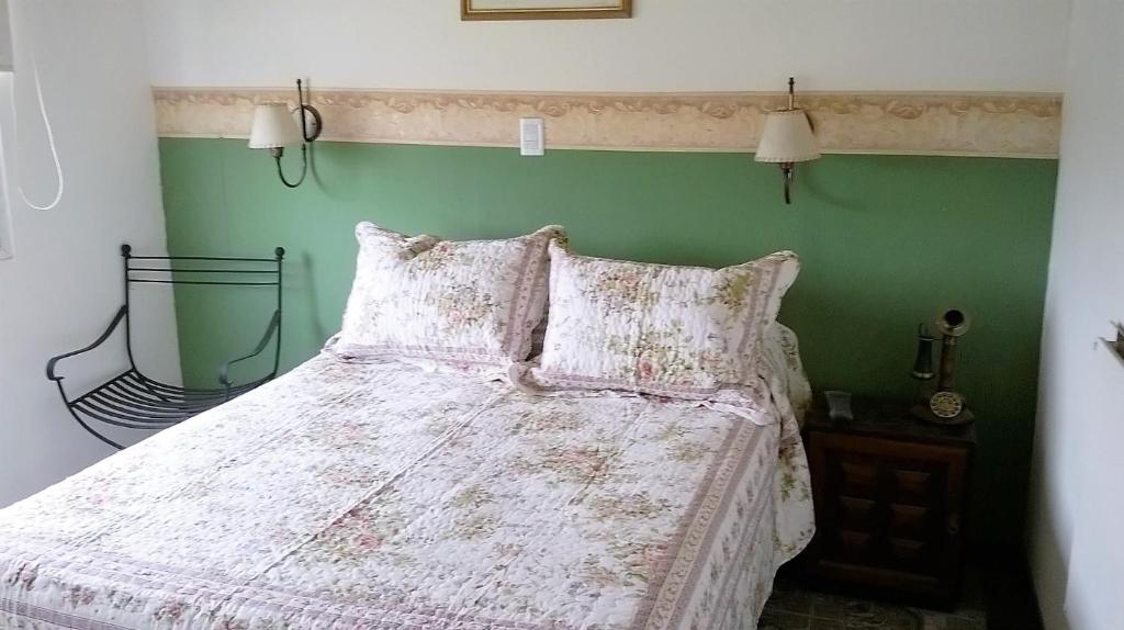 a bedroom with a bed with a green wall at Posada La Pausa - Solo para Adultos in Miramar