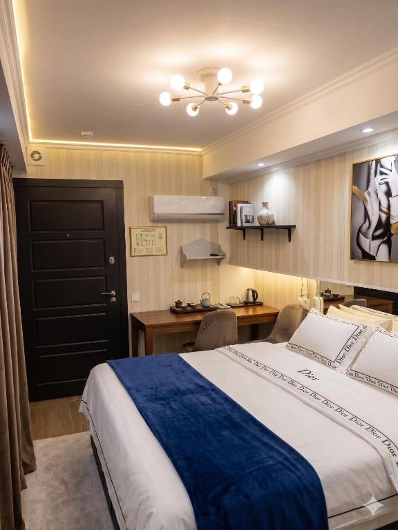 a bedroom with a large bed with a desk and a table at Moldavian Luxury in Chişinău