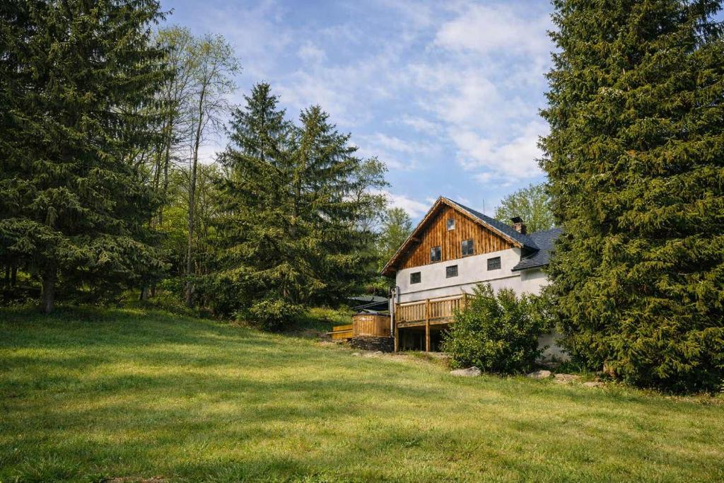 a house in a field with trees and grass at Chachata Jeseniky sauna & jacuzzi in Dolní Moravice