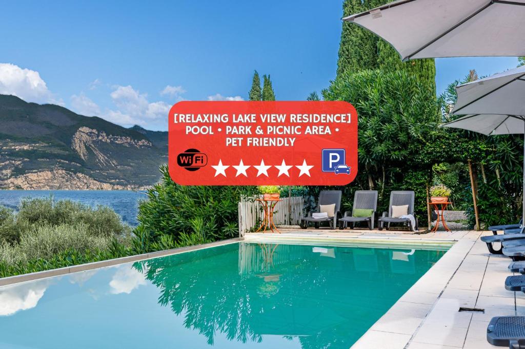 a sign next to a swimming pool at a resort at Panoramic Lake View Apartments with Pool & Breakfast in Torri del Benaco