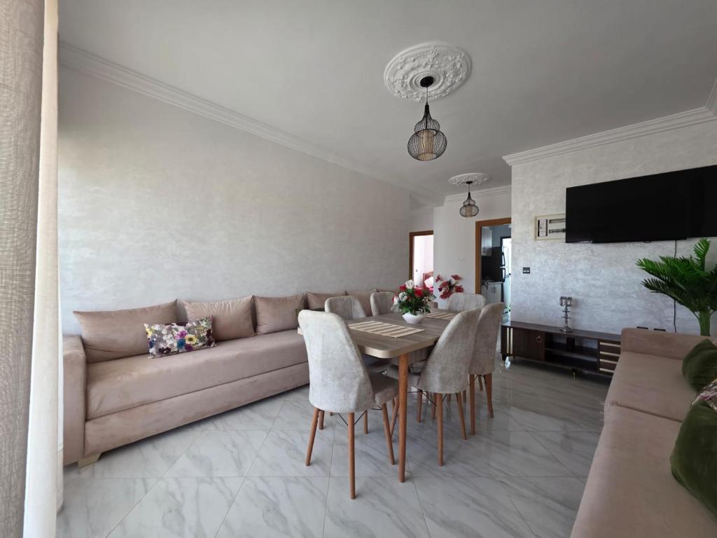 a living room with a couch and a table and chairs at Appartement sur Mer in El Arba de Trougout