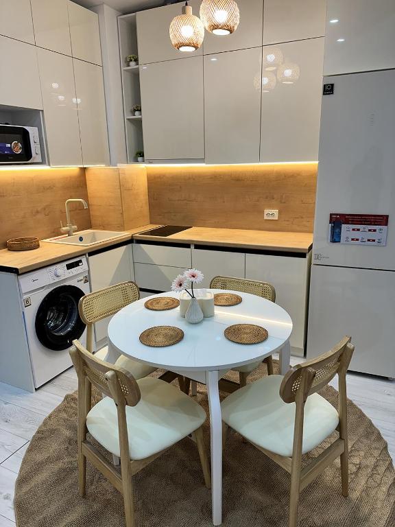 a kitchen with a white table with chairs and a sink at Wings Zen in Bosteri