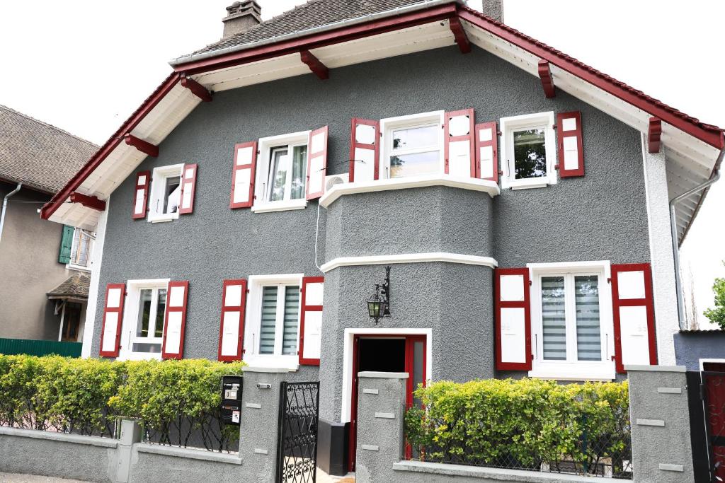a gray house with red and white shuttered windows at Villa Bellevue Genève in Annemasse