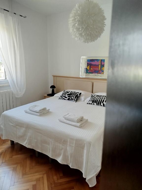 a bedroom with a bed with two towels on it at ROOMS LUCE 2 & Supetar in Supetar