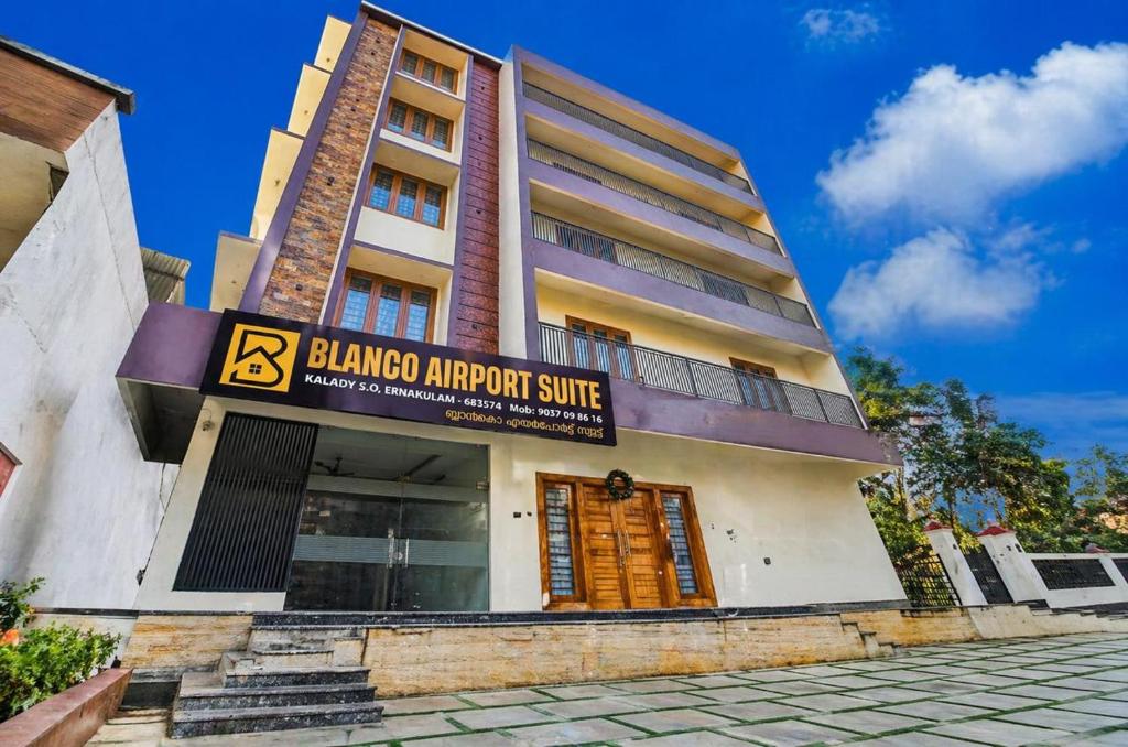 a building with a sign that reads blinder airport shuttle at Blanco Airport Suite in Kāladi