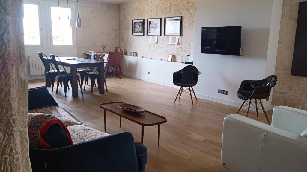 a living room with a couch and a table and chairs at Superbe appartement avec vue in Arles