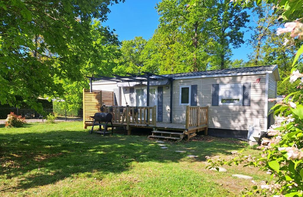 a tiny house with a porch and a deck at Chez Achille in Marcilly-sur-Eure
