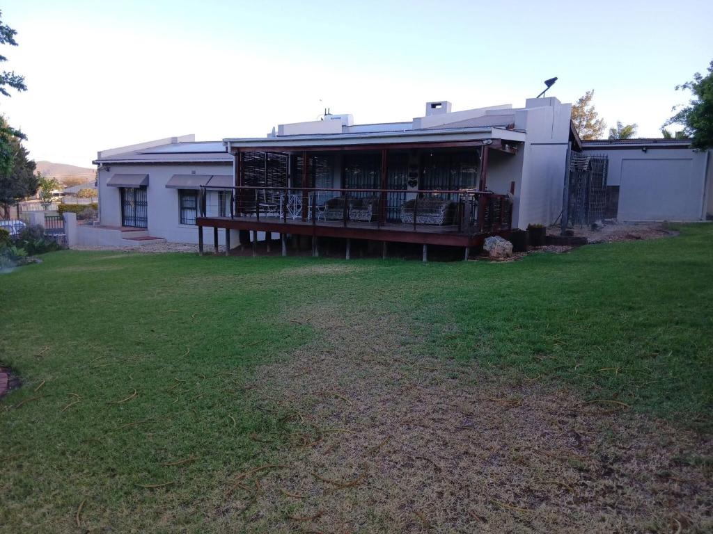 a house with a porch and a yard at Healboys Self - catering Accommodation in Bonnievale