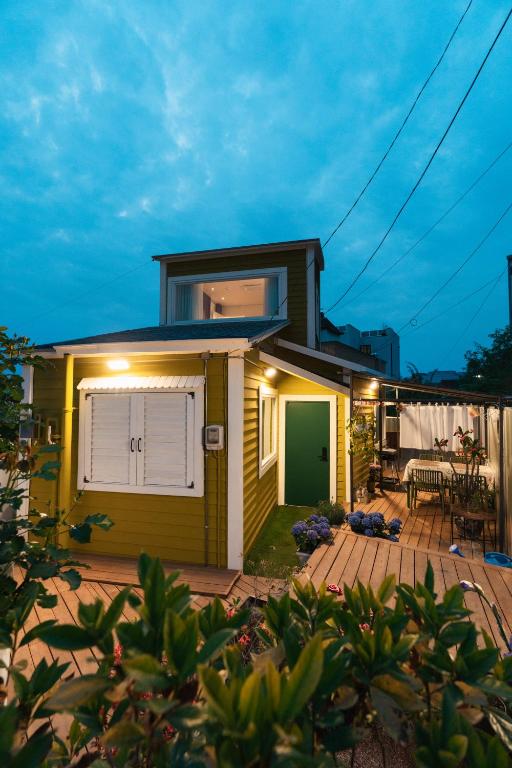 a small yellow house with a white garage at Stay SUM in Kwarye