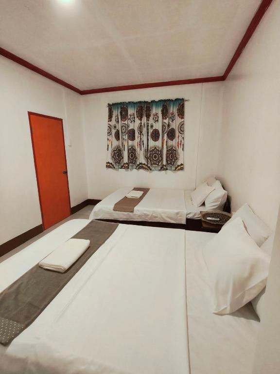 a white room with two beds and a window at Tugbongan North Siargao in Burgos