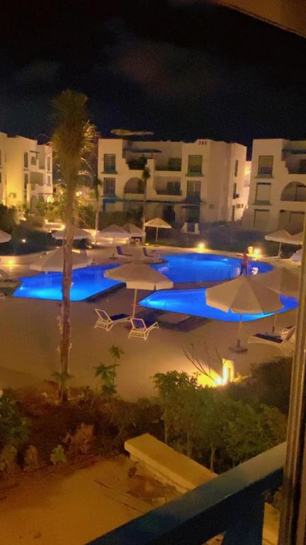 a view of a pool with umbrellas at night at MV Ras El Hakma 190 A in Ras Elhekma