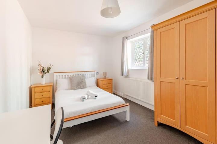 a bedroom with a white bed and a window at Spacious Riverside View Bungalow in Oxford