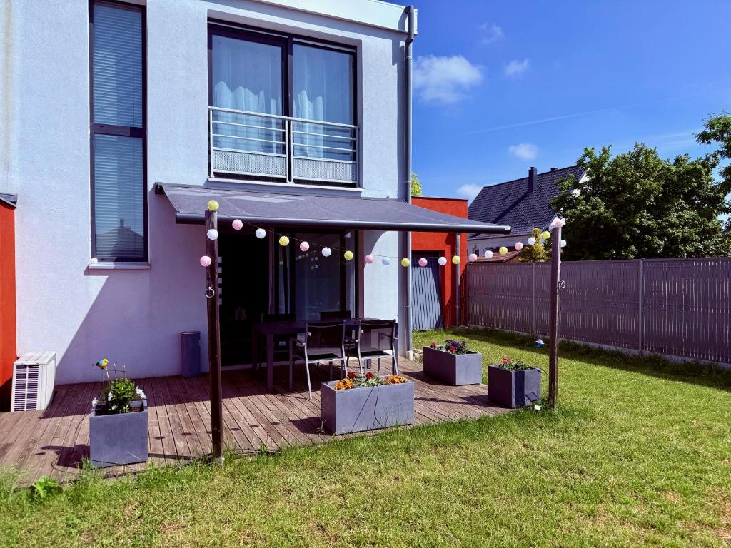 a house with a deck with a table in the yard at Appartement comme une Maison in Ingersheim