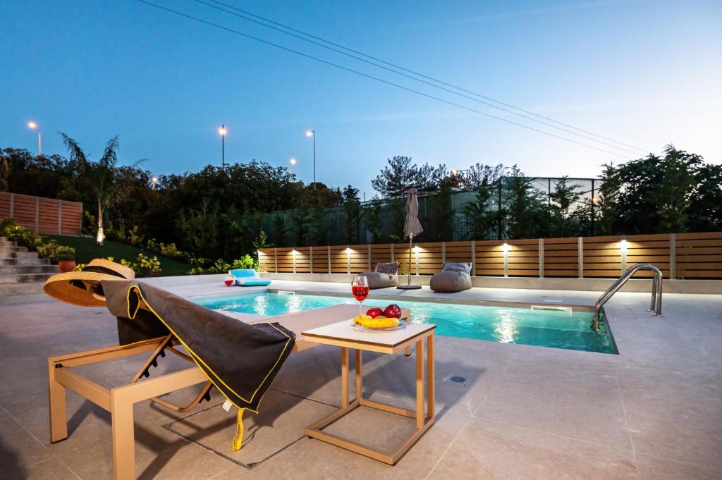 a swimming pool with a chair and a table next to a pool at Casa Di Aspa-Serene Escape with Pool near town in Rethymno