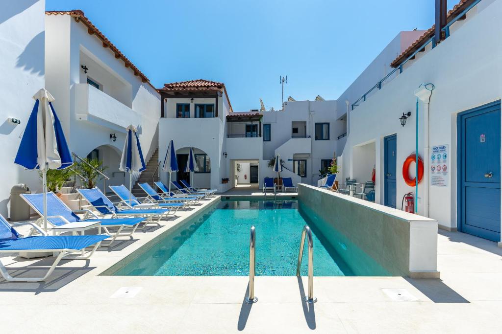 a swimming pool with chairs and a hotel at Iliana Hotel in Panormos Rethymno