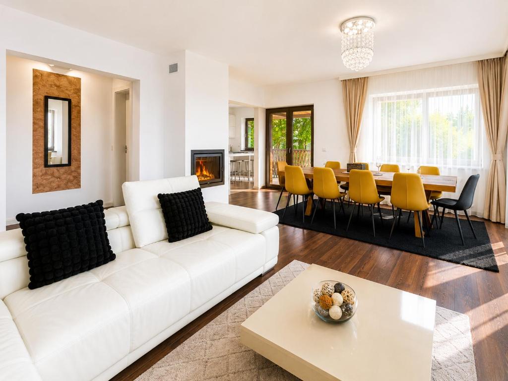 a living room with a white couch and a table at Vila Panorama - Bunloc in Săcele