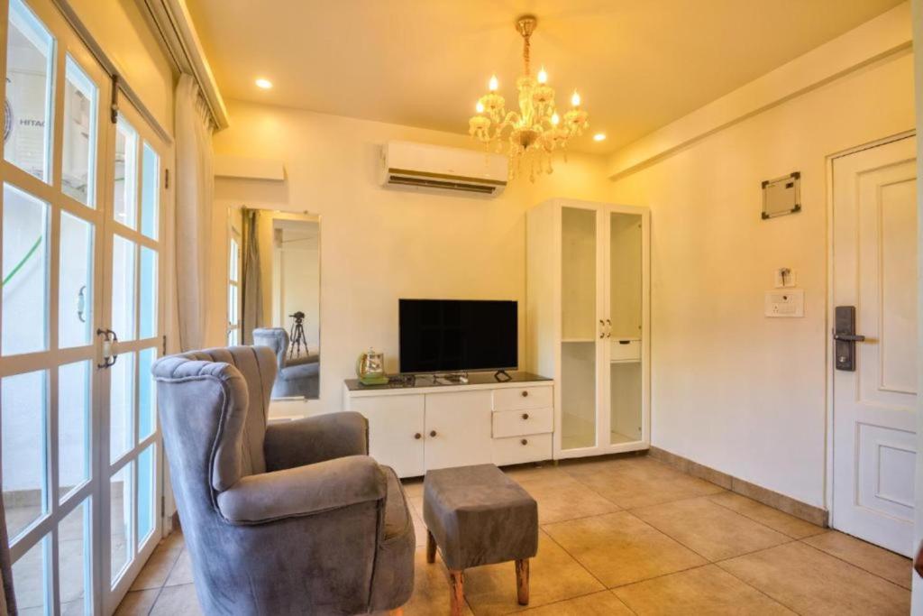 a living room with a chair and a television at Casa Pajaros in Calangute