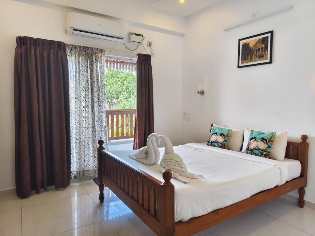 a bedroom with a large bed in front of a window at RVS Chalet in Pondicherry