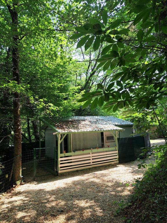 a small white building with a fence and trees at Gîtes du Bois de Bontemps in Sarlat-la-Canéda