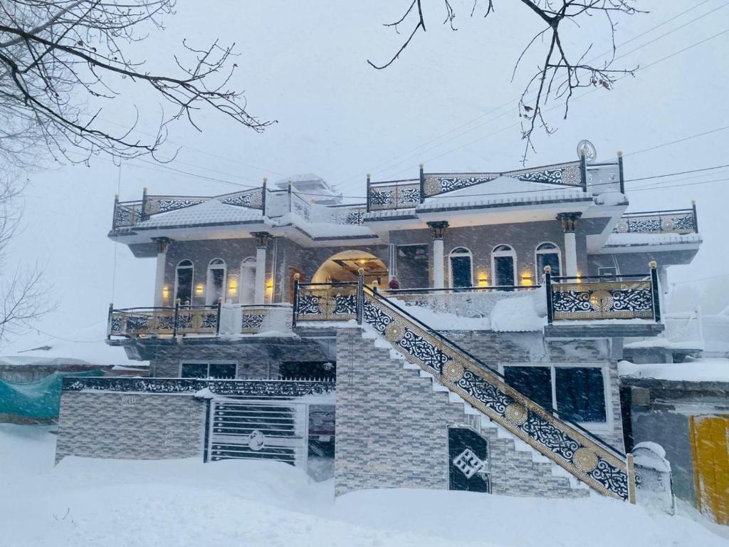 a house covered in snow in front at The Balaj Cottages in Kālābāgh